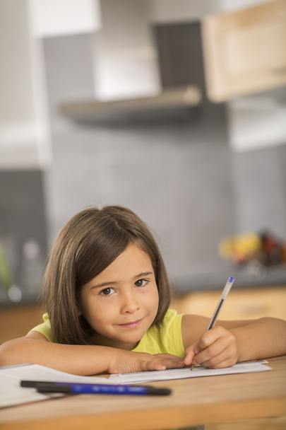Portrait of little girl doing homework ar table - Photo, Image