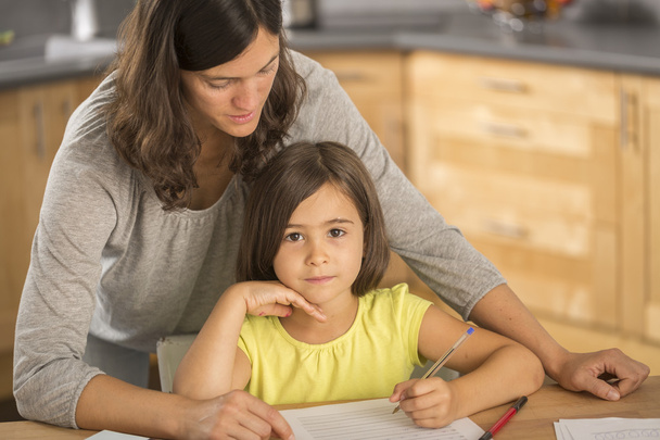 Mother and daughter doing homework together. - 写真・画像