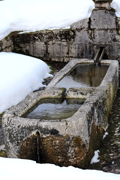 fontaine en pierre avec eau froide glacée en hiver
 - Photo, image