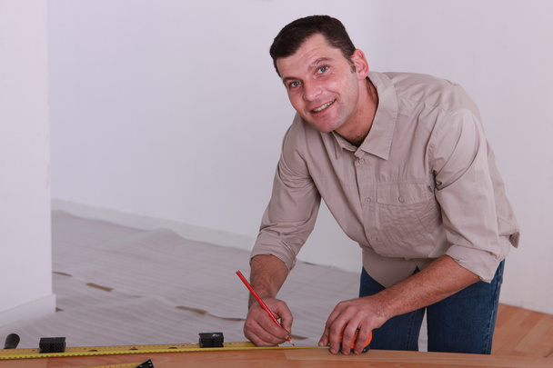 Торговец маркирует измерение на деревянной доске
 - Фото, изображение