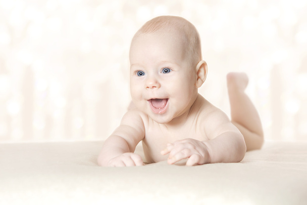 ευτυχισμένο μωρό ενεργό που βρίσκεται στο στομάχι πέρα από την κουβέρτα - Φωτογραφία, εικόνα