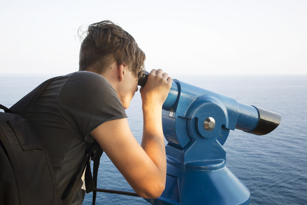 Teenager surveillances through telescope - Photo, Image