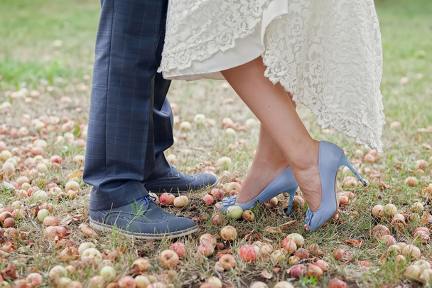 τα πόδια της νύφης και του γαμπρού, από κοντά, στο φθινόπωρο μήλο οπωρώνα - Φωτογραφία, εικόνα