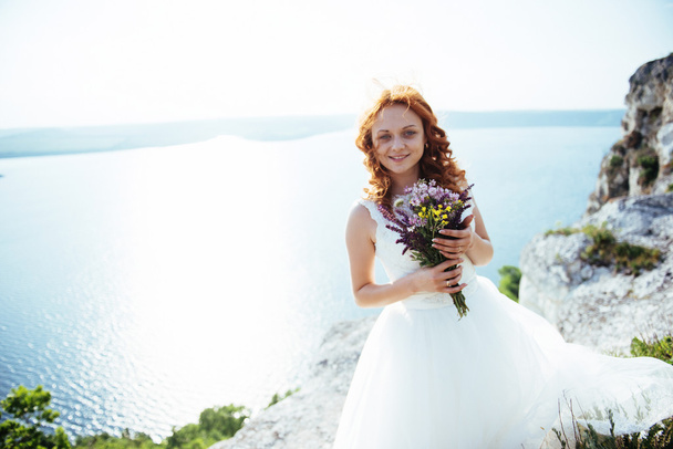 bride with a bouquet of flowers near the water - Photo, Image