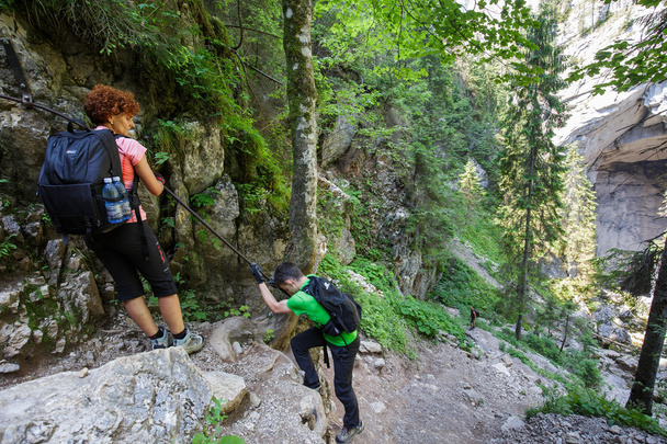 hikers climbing on a safety cable - Foto, afbeelding