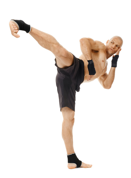 Kickboxer executing a powerful kick - Zdjęcie, obraz
