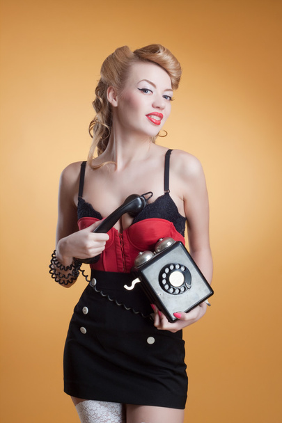 Beautiful young girl with a vintage telephone survey in retro style - Fotoğraf, Görsel