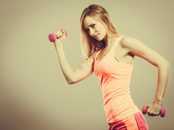 Muscular blonde girl lifting weights - 写真・画像