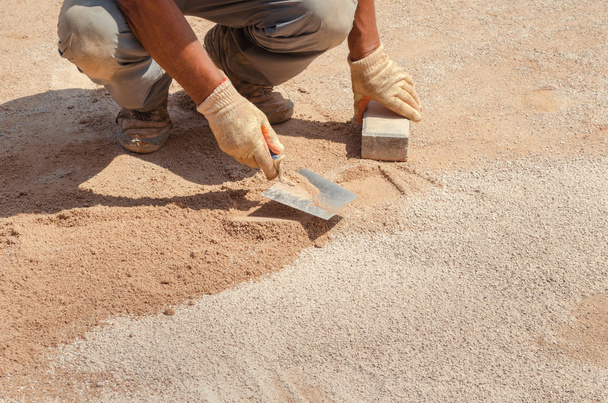 werknemer met een troffel plat zand - Foto, afbeelding
