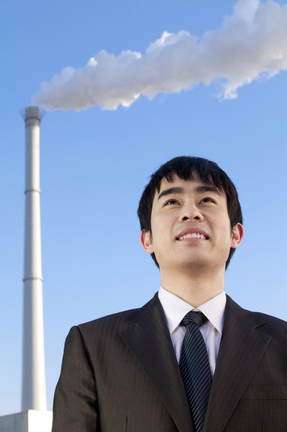 Businessman in Front of Smokestack - Photo, Image
