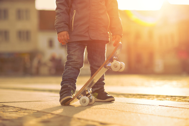 Child with skateboard on the street - Φωτογραφία, εικόνα