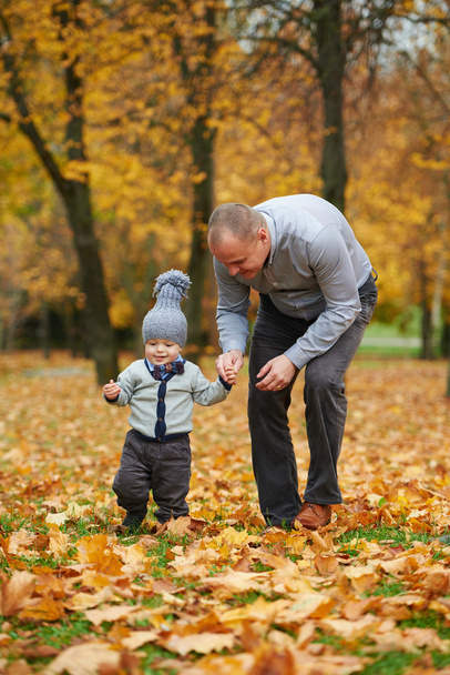 father with son walking in autumn forest - Fotoğraf, Görsel