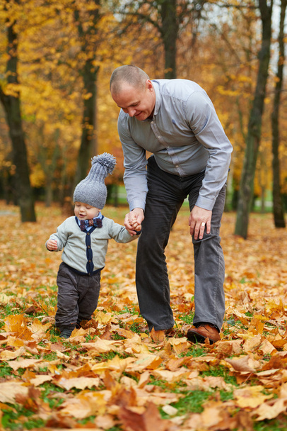 father with son walking in autumn forest - 写真・画像