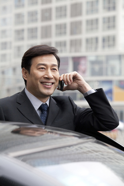 Businessman talking on phone outdoors - Photo, Image