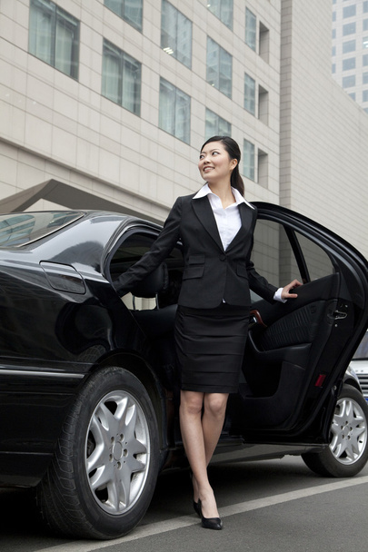 Businesswoman stepping out a car - Foto, afbeelding