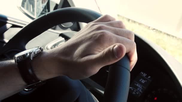 Nahaufnahme einer männlichen Hand am Lenkrad eines modernen Autos - Filmmaterial, Video