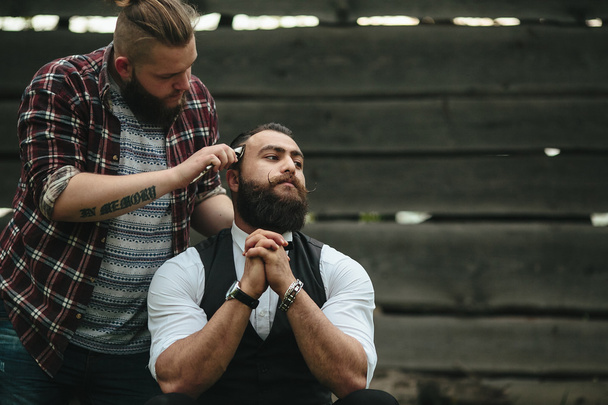 перукар голить бородатого чоловіка
 - Фото, зображення