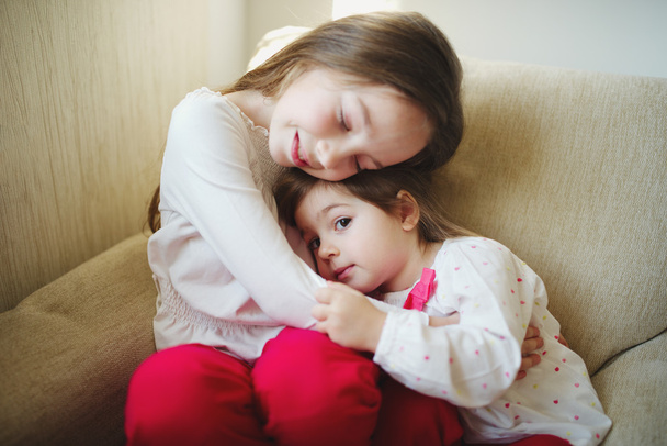 girl hugging her younger sister - Фото, зображення