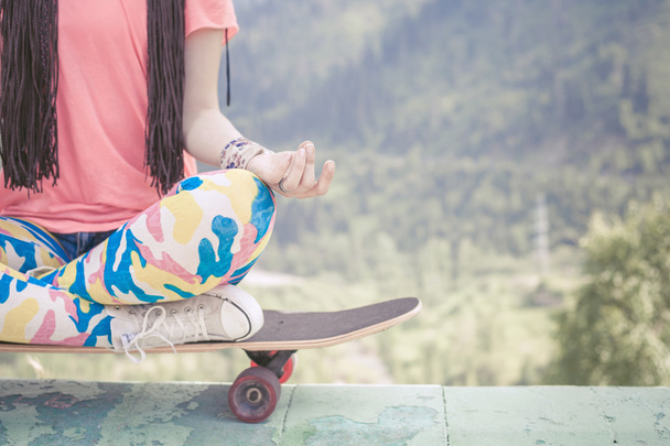 hippie fashion girl doing yoga, relaxing on skateboard at mountain - Φωτογραφία, εικόνα
