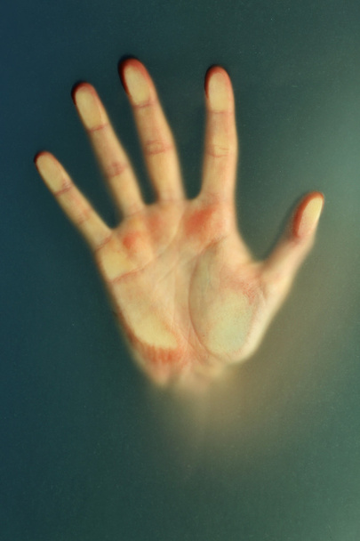 Female hand behind  wet glass - Valokuva, kuva
