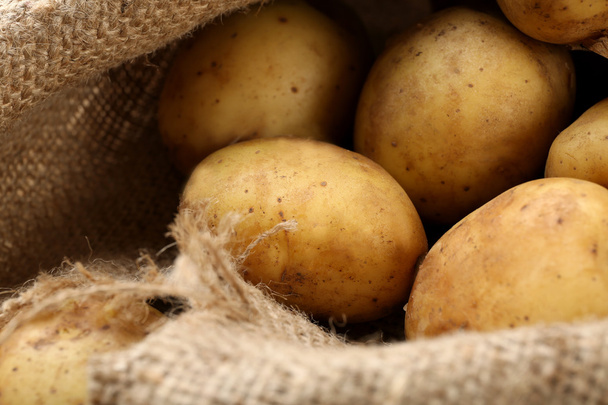 Young potatoes on sackcloth close up - Foto, Imagen