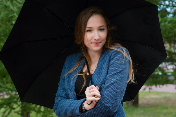 Νεαρή έφηβη γυναίκα με μαύρη ομπρέλα στο πάρκο - Φωτογραφία, εικόνα