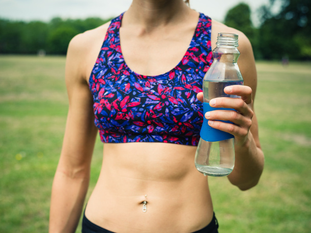 Fit woman with water bottle in park - Foto, Imagem