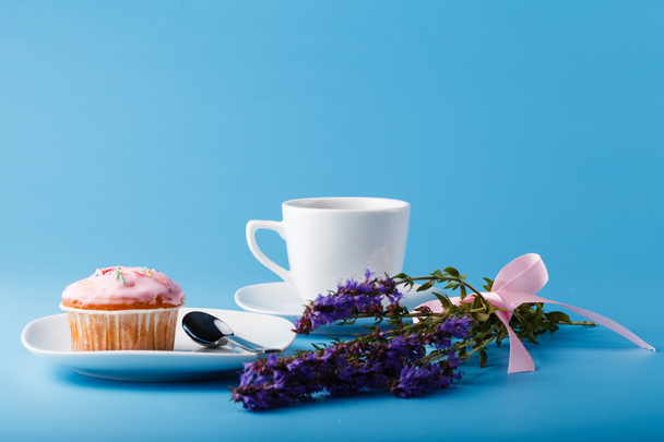 Colorful muffin on saucer with flowers  - Photo, Image