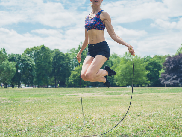 Woman skipping in the park - Foto, afbeelding