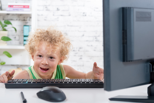 小さな金髪の少年がコンピューターで遊ぶ - 写真・画像