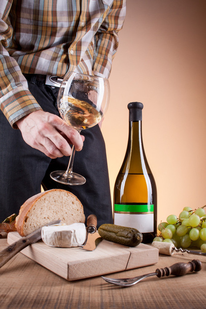 Flasche Weißwein und Trauben auf einem Holztisch - Foto, Bild