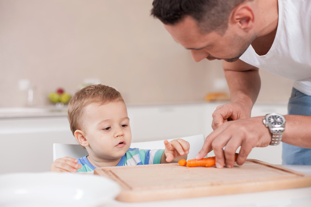 Attractive young father is cooking for his child - Foto, afbeelding