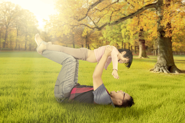 Father lifting his daughter at autumn park - Foto, immagini