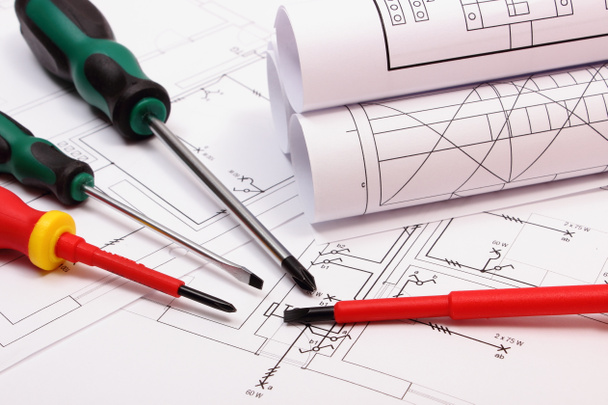 Rolos de diagramas e ferramentas de trabalho no desenho de construção elétrica de casa
 - Foto, Imagem