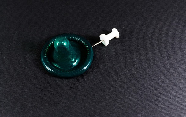 Condoom en een Pin Prick - Foto, afbeelding