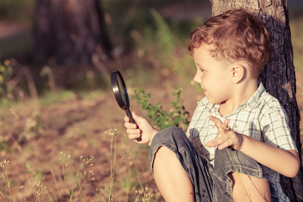 Happy little boy exploring nature with magnifying glass - Foto, Imagem