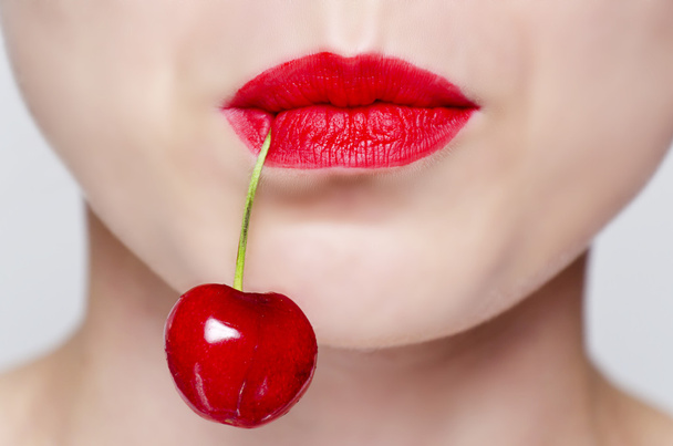 naisen kasvot punaisella huulipunalla ja kirsikka
 - Valokuva, kuva