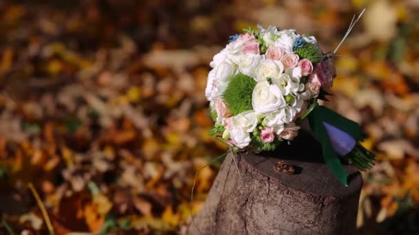 Boeket van de bruid op de gele bladeren en trouwringen - Video