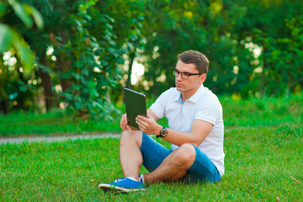 jonge man met een touchpad buiten - Foto, afbeelding