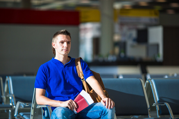 Young man holding passports and boarding pass at airport - Photo, Image