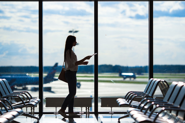 飛行機を待っている空港ラウンジで航空旅客のシルエット - 写真・画像