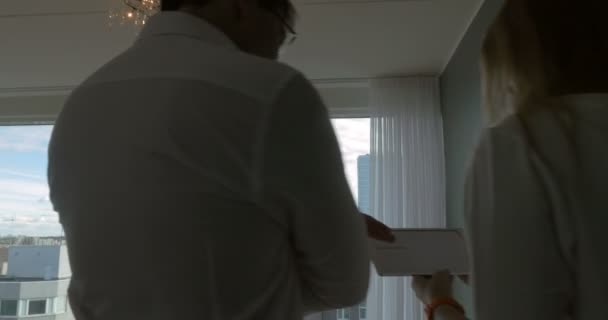 窓際でおしゃべりをしているパッドを持つビジネスマン - 映像、動画