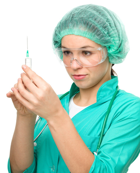 Young nurse is preparing syringe for injection - 写真・画像