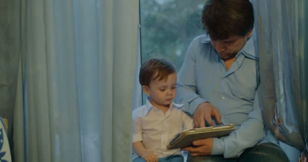 Πατέρας και Υιός βλέποντας κινούμενα σχέδια στο tablet - Πλάνα, βίντεο