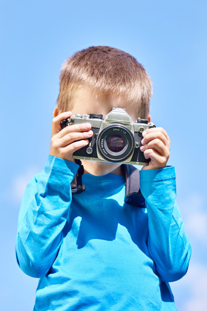 Little boy with retro SLR camera on blue sky - Foto, Imagem