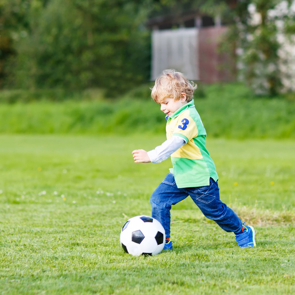 Двоє маленьких хлопчиків-братів грають у футбол і футбол на полі
 - Фото, зображення