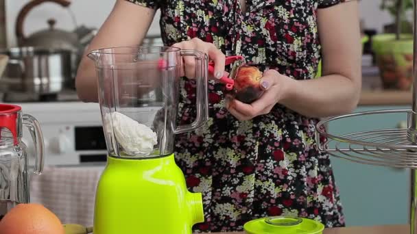 Γυναίκα με φρούτα στην κουζίνα κοντά σε μπλέντερ - Πλάνα, βίντεο