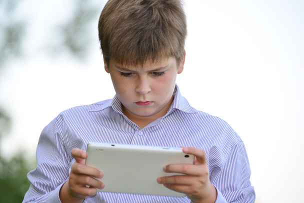 Teen boy with  tablet computer at nature - Foto, afbeelding