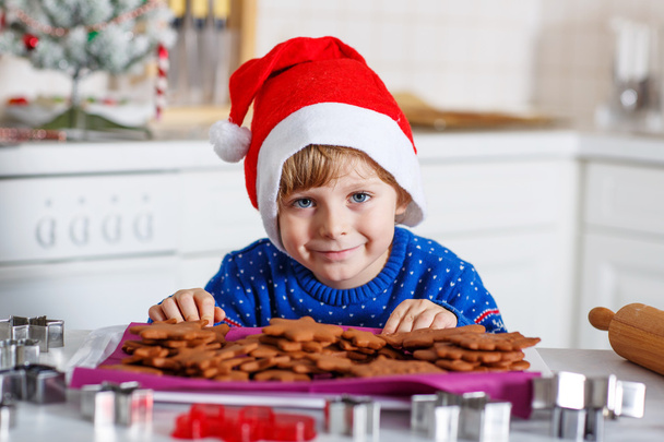Little boy baking gingerbread cookies in domestic kitchen - Zdjęcie, obraz
