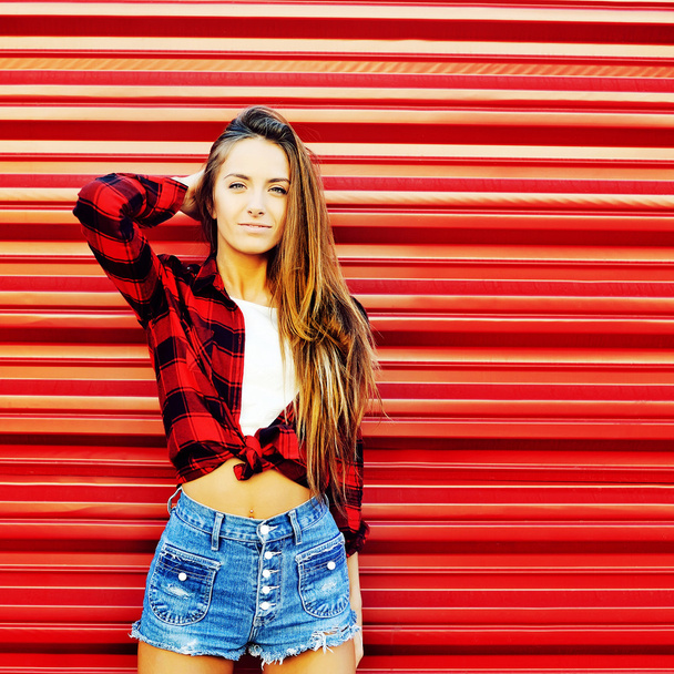 Çekici genç kadın kırmızı duvara yakın - boşaltmak poz  - Fotoğraf, Görsel